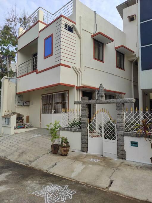 a large white house with a gate in front of it at Muktamma in Tiruvannāmalai