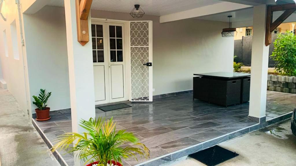 a front porch of a house with a white door at Villa de 2 chambres avec vue sur la ville piscine privee et jardin clos a Le Lamentin in Le Lamentin