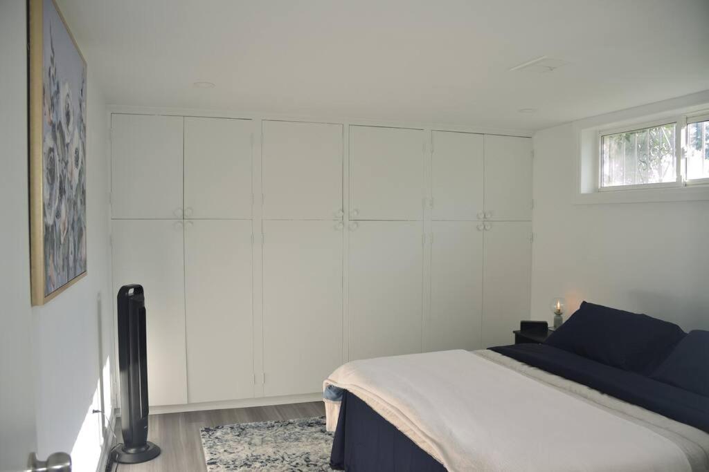 um quarto branco com uma cama e uma janela em Entire Basement - 5 Guests 2 Bedrooms 3 Beds em Toronto