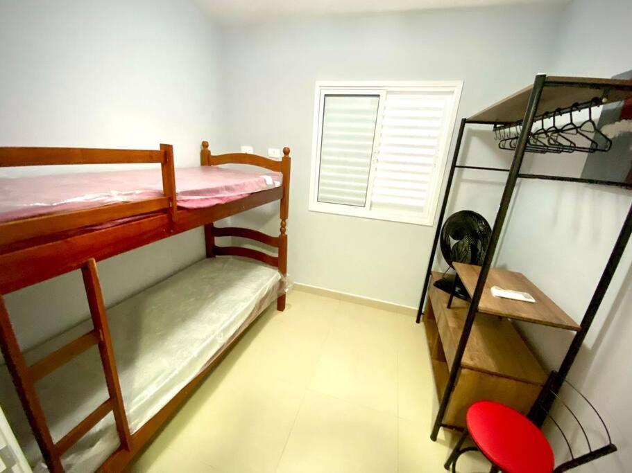 a room with two bunk beds and a window at Apto. aconchegante in Ubatuba