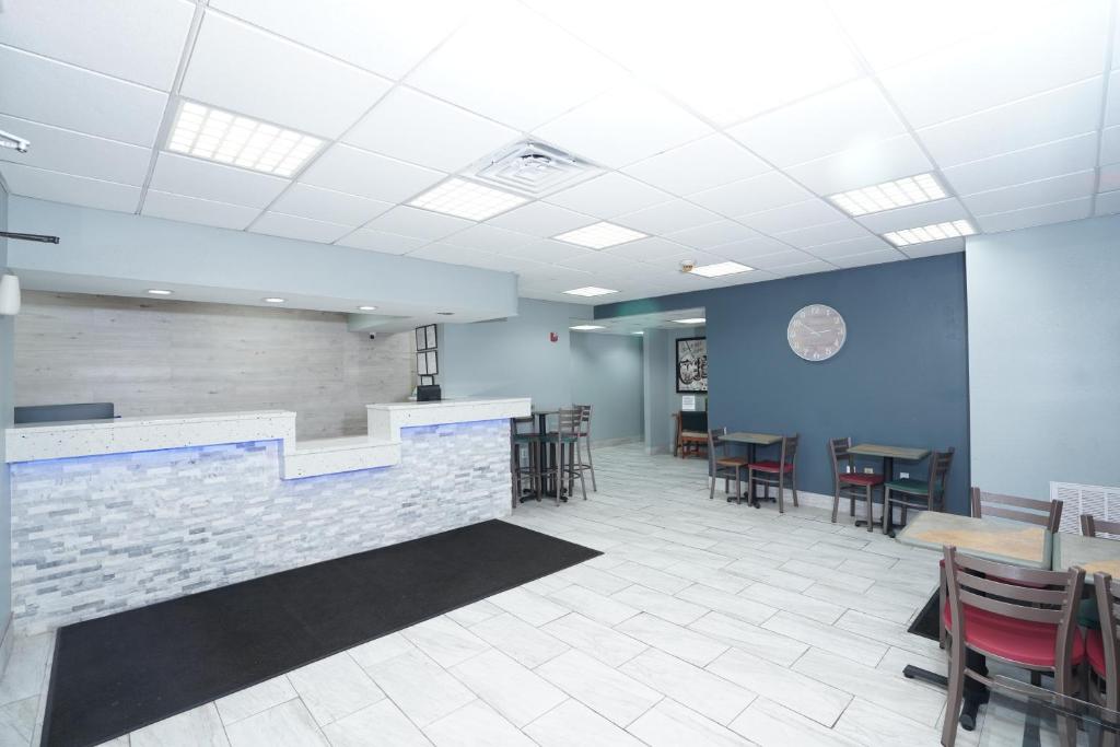 a waiting room with tables and chairs and a bar at Red Carpet Inn & Suites in Newnan