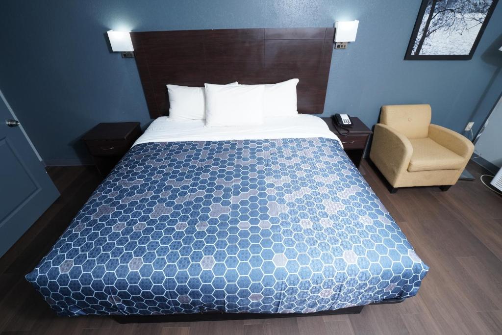 a bedroom with a bed and a chair at Red Carpet Inn & Suites in Newnan