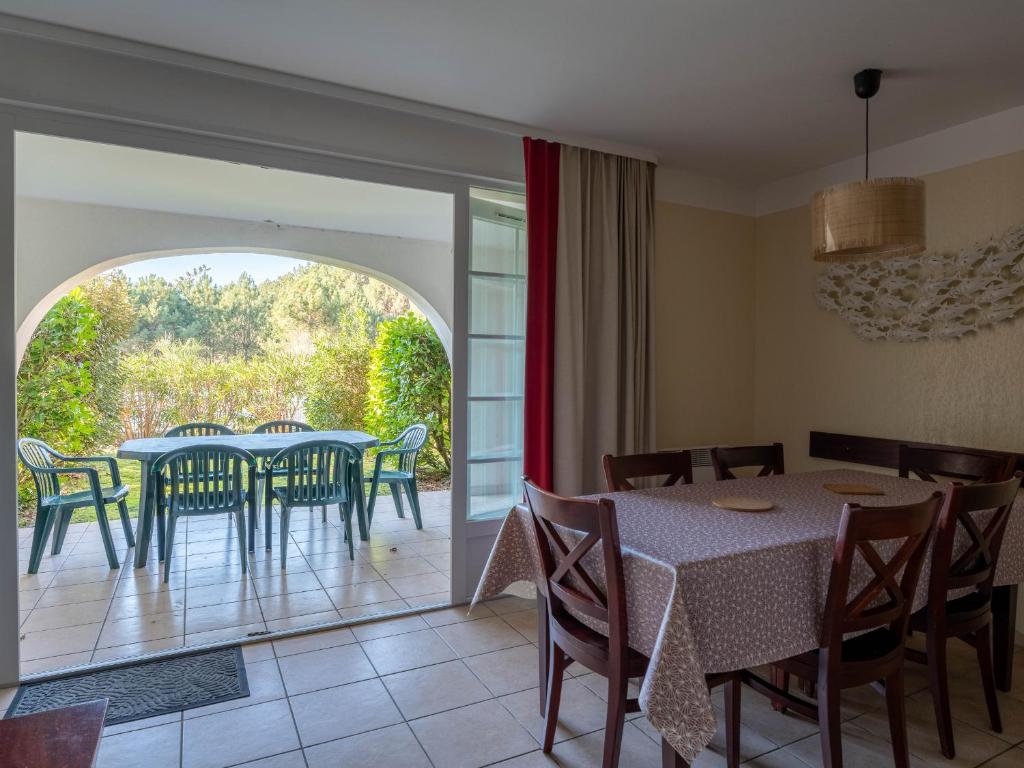 a dining room with a table and chairs at Appartement à Biscarrosse avec Piscine, Boulodrome et Terrasse – 7 Personnes, Ménage Inclus - FR-1-319-497 in Biscarrosse
