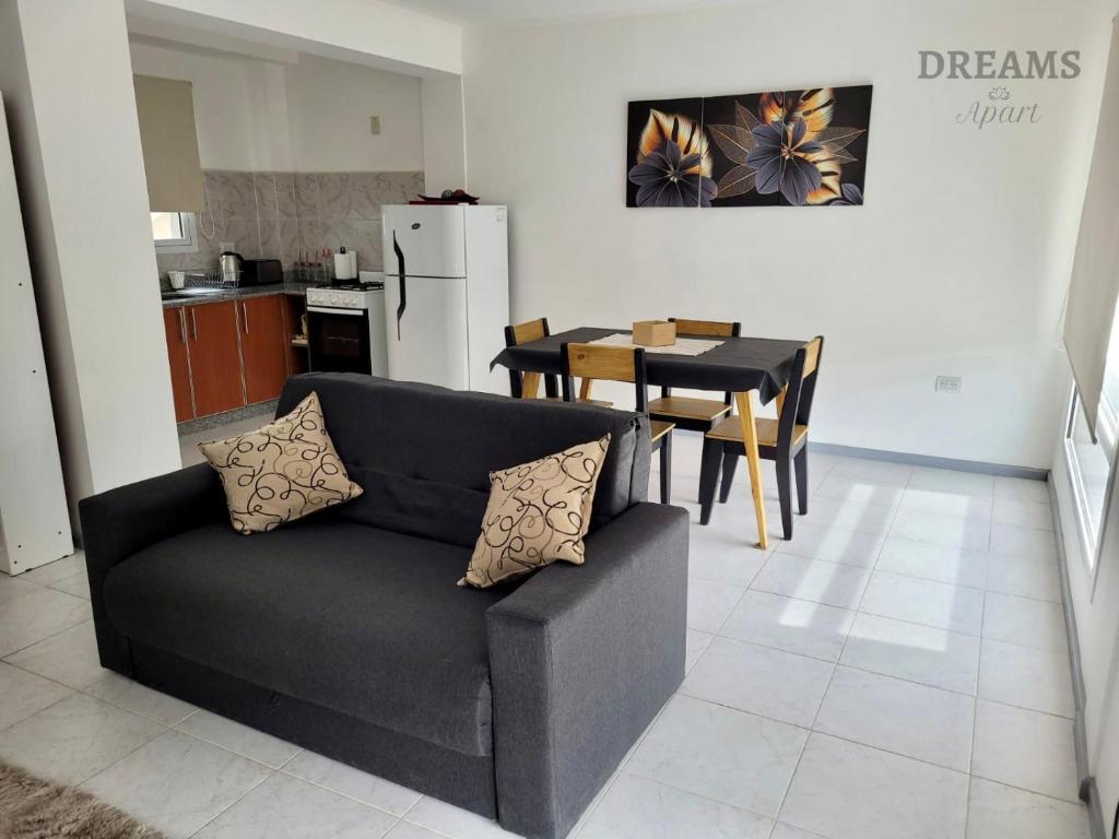 a living room with a black couch and a kitchen at Dreams in Río Gallegos