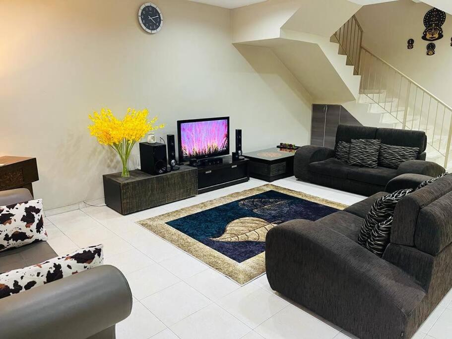 a living room with a couch and a tv at Semi -D Homestay Seremban 2 in Seremban