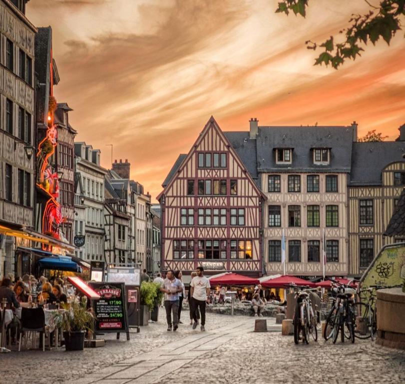 um grupo de pessoas andando por uma rua com edifícios em Le secret d’Adam em Rouen