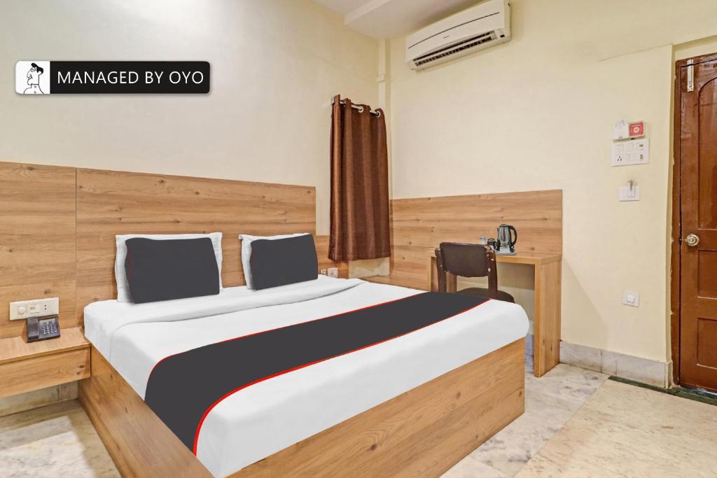 a bedroom with a large bed with a desk and a window at Super Collection O Townvilla Guest House near Begumpet Metro Station in Hyderabad