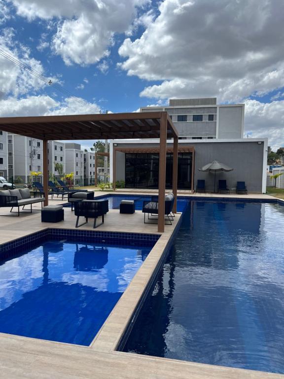 a swimming pool with a pergola next to a building at Condomínio Indianopolis a 1,4km do North Shopping in Caruaru