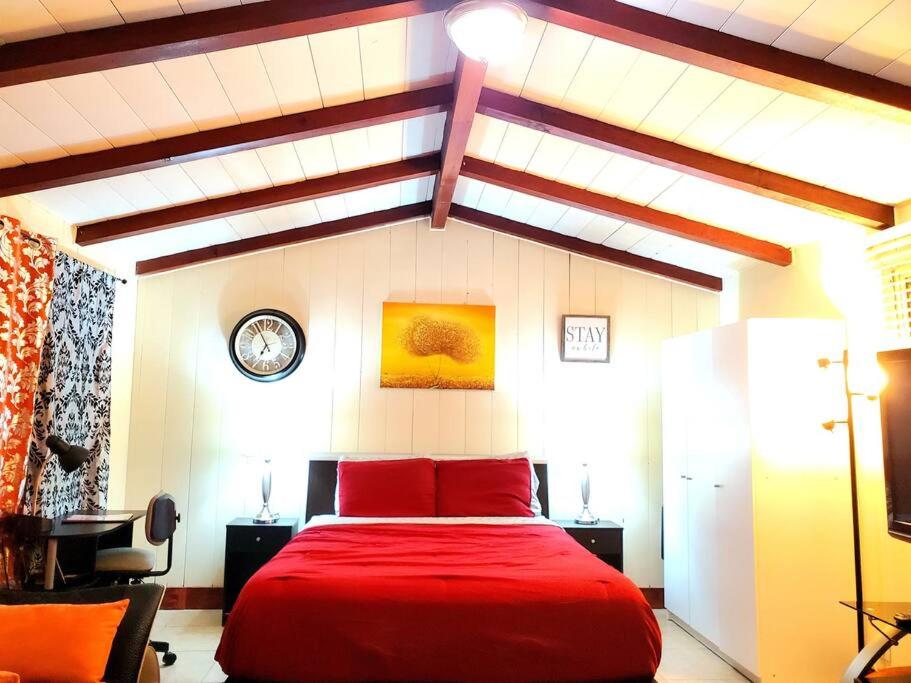 een slaapkamer met een rood bed en een klok aan de muur bij Guest house-perfect getaway - relaxing space in Temple City