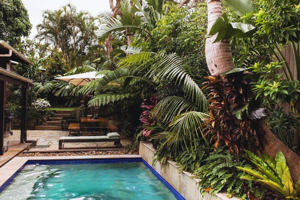 a swimming pool in the middle of a garden at Beach Jungle - Hot Tub, Firepit & Pool in Beachside Oasis in Byron Bay
