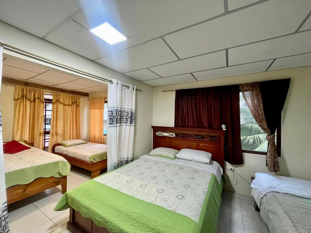 阿約拉港的住宿－Nelyza's Suites & Adventure，一间卧室设有两张床和窗户。