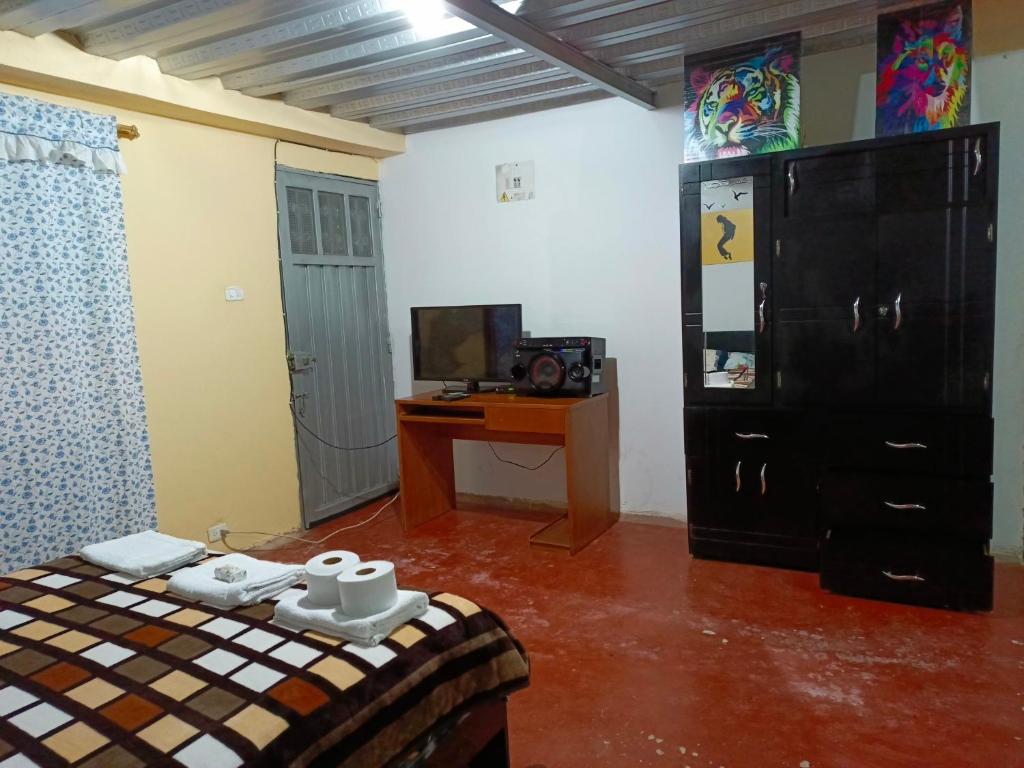 een kamer met een bed, een bureau en een televisie bij Apartamento semi Urbano 