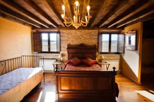 a bedroom with a bed and a chandelier at La Morada del Cid Burgos in Vivar del Cid