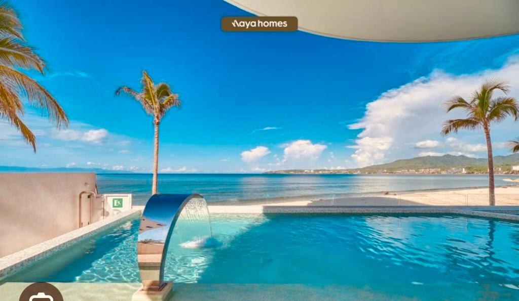 een zwembad met uitzicht op het strand bij Apartamento en Bucerías frente al mar, condominio Tayau in Bucerías