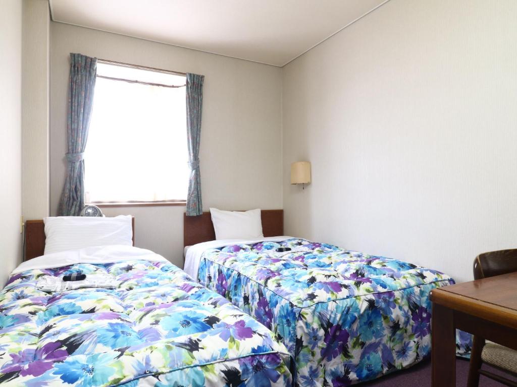 Postel nebo postele na pokoji v ubytování Shinseto Station Hotel