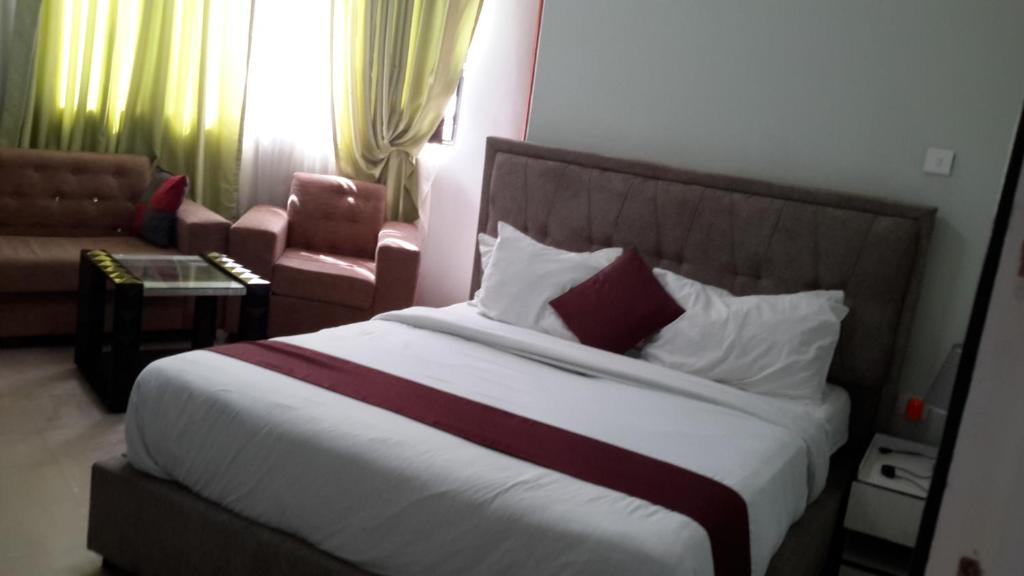 a bedroom with a bed and a couch and a chair at Danakil Hotel in Addis Ababa