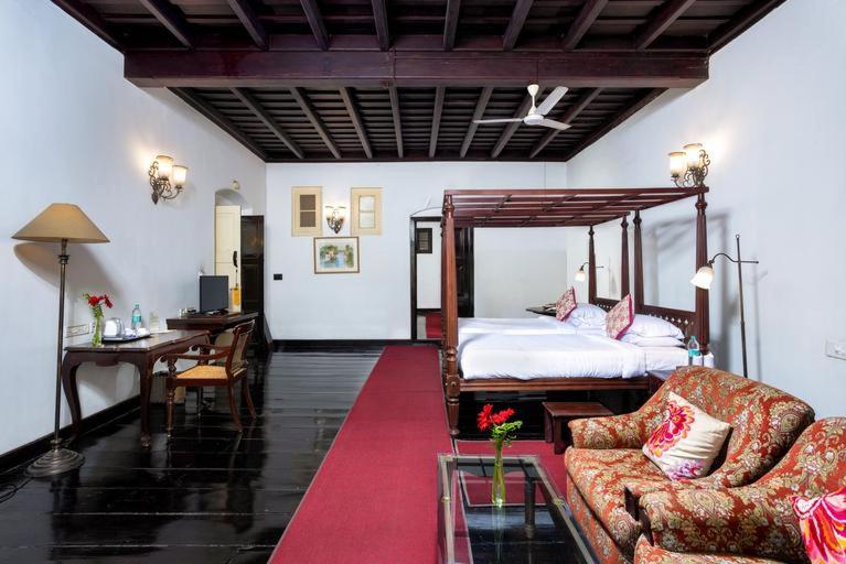 um quarto com uma cama, uma secretária e um sofá em Koder House em Cochin