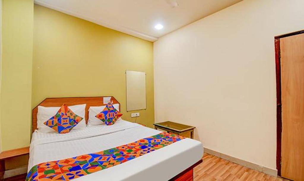 1 dormitorio con 1 cama grande y almohadas coloridas en FabHotel Kamala Inn en Kotrung