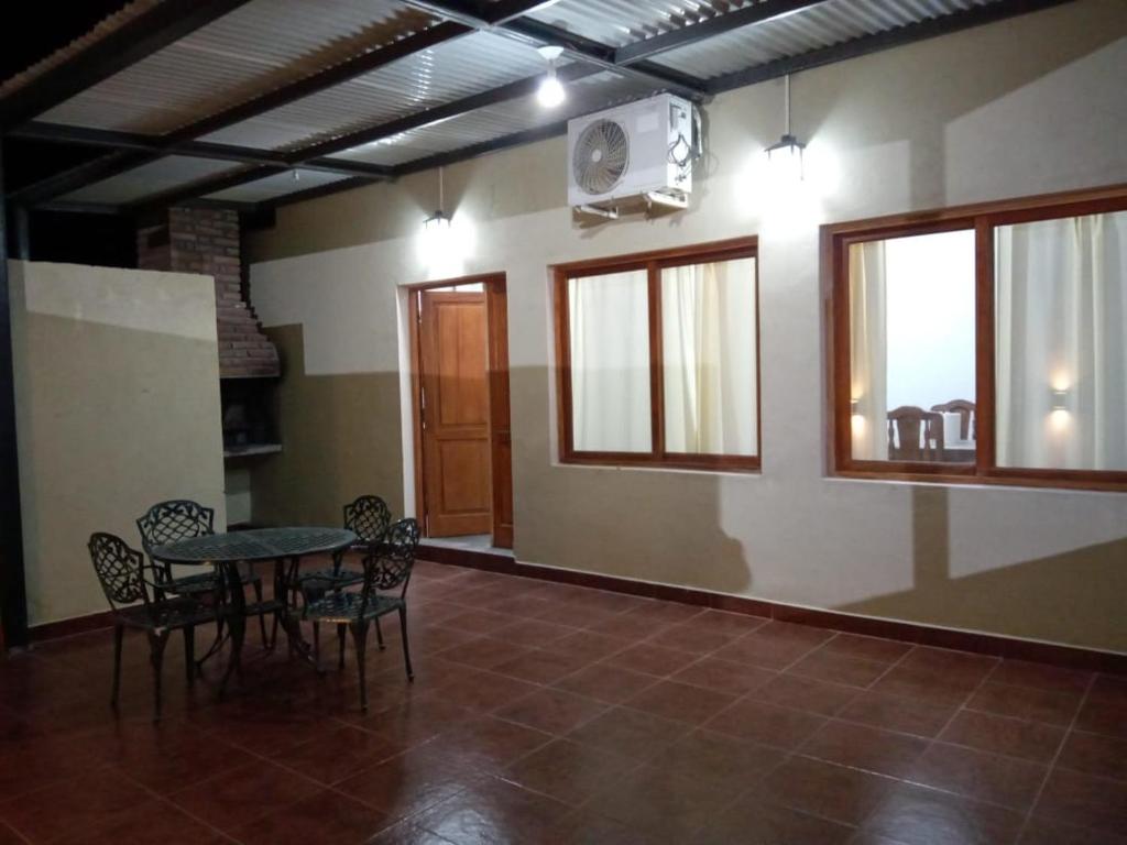 comedor con mesa, sillas y ventanas en Vistas del Colorado en Cafayate