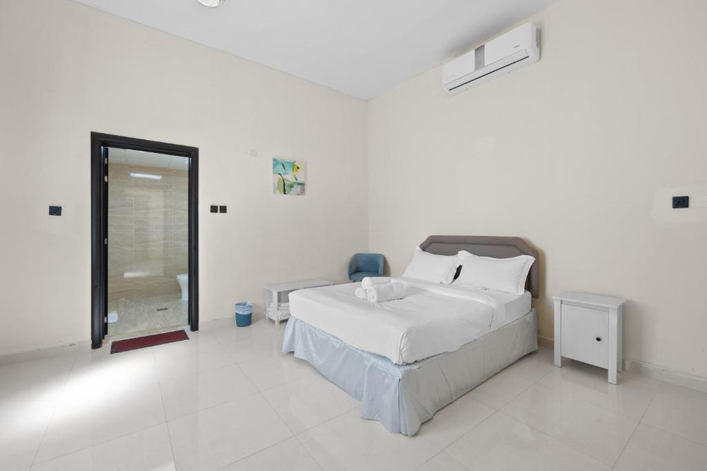 ein weißes Schlafzimmer mit einem Bett und einem Fenster in der Unterkunft Terminal Majesty Villa Haven 3bedroom near DXB T3 in Dubai