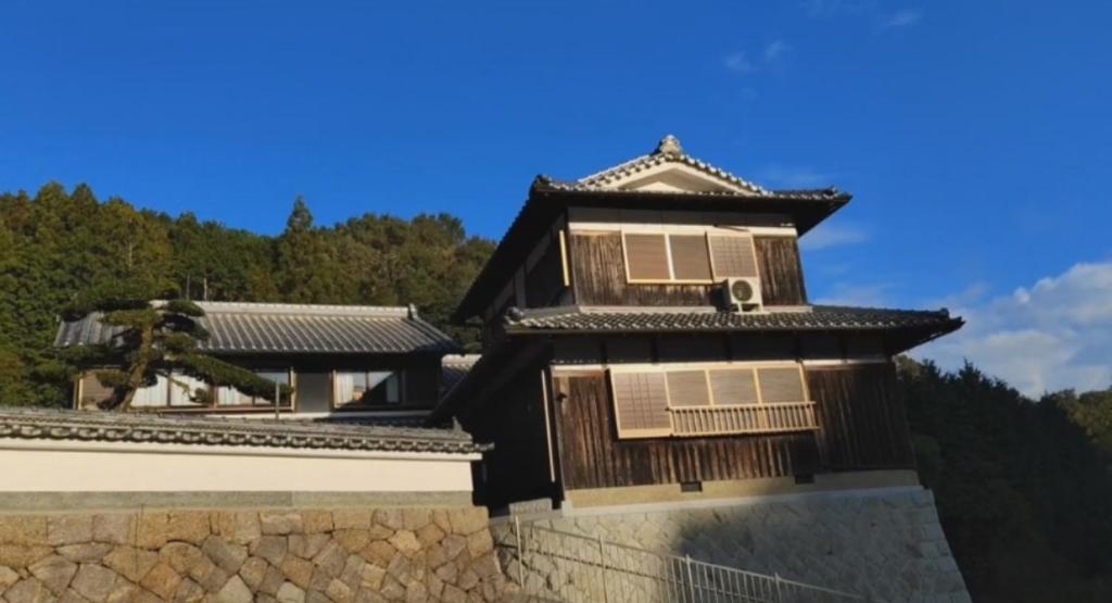 un edificio en una pared con un cielo azul en SEIYU宿, en Nara