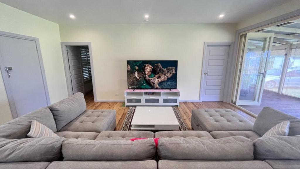 ein Wohnzimmer mit 2 Sofas und einem Flachbild-TV in der Unterkunft Unwind On Ellmoos in Sussex inlet