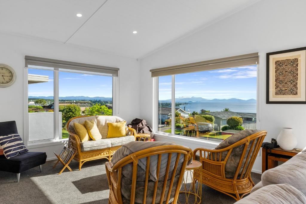 un soggiorno con sedie e una grande finestra di Scenic Lake Views - Taupo Holiday Home a Taupo