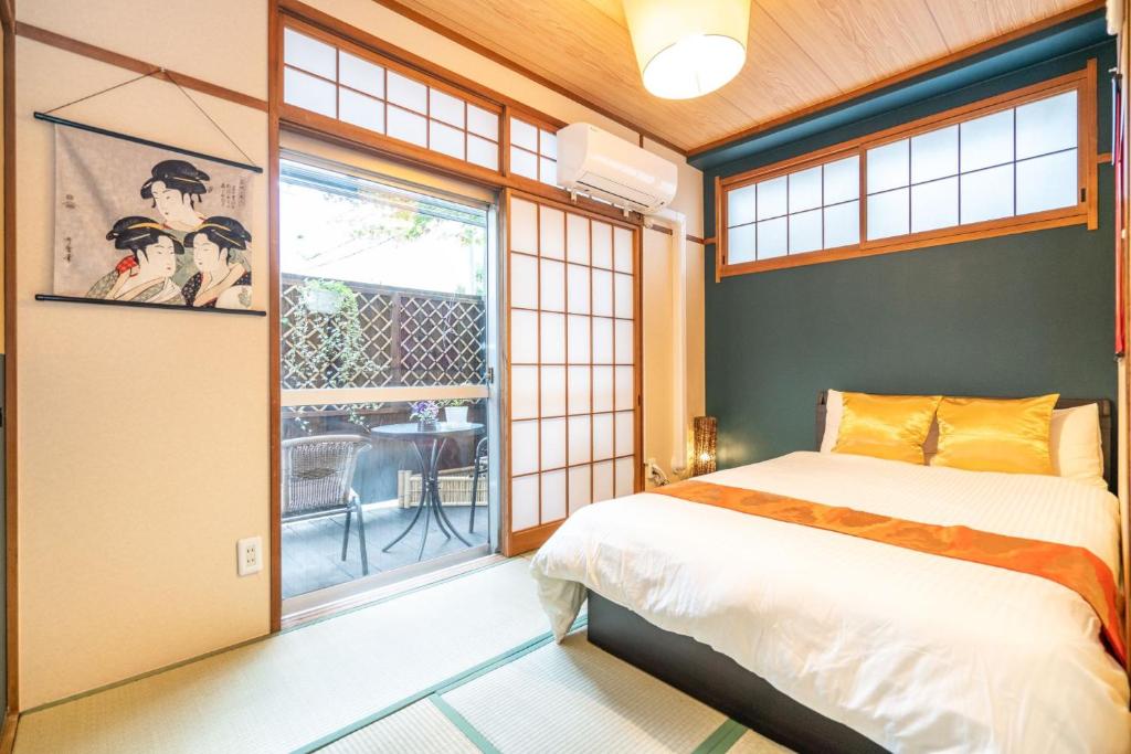 a bedroom with a bed and a door to a patio at KYARA Hotel 白鳥 in Tokyo