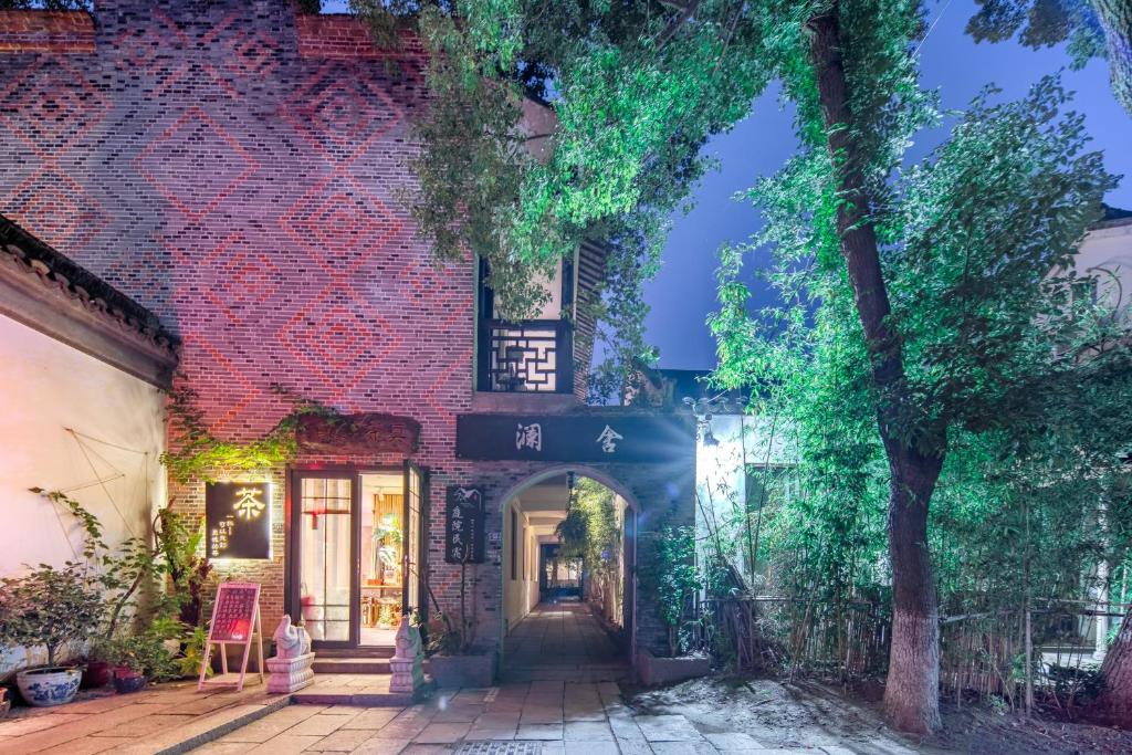 een bakstenen gebouw met een boog ervoor bij Tongli Lanshe Garden B&B in Suzhou