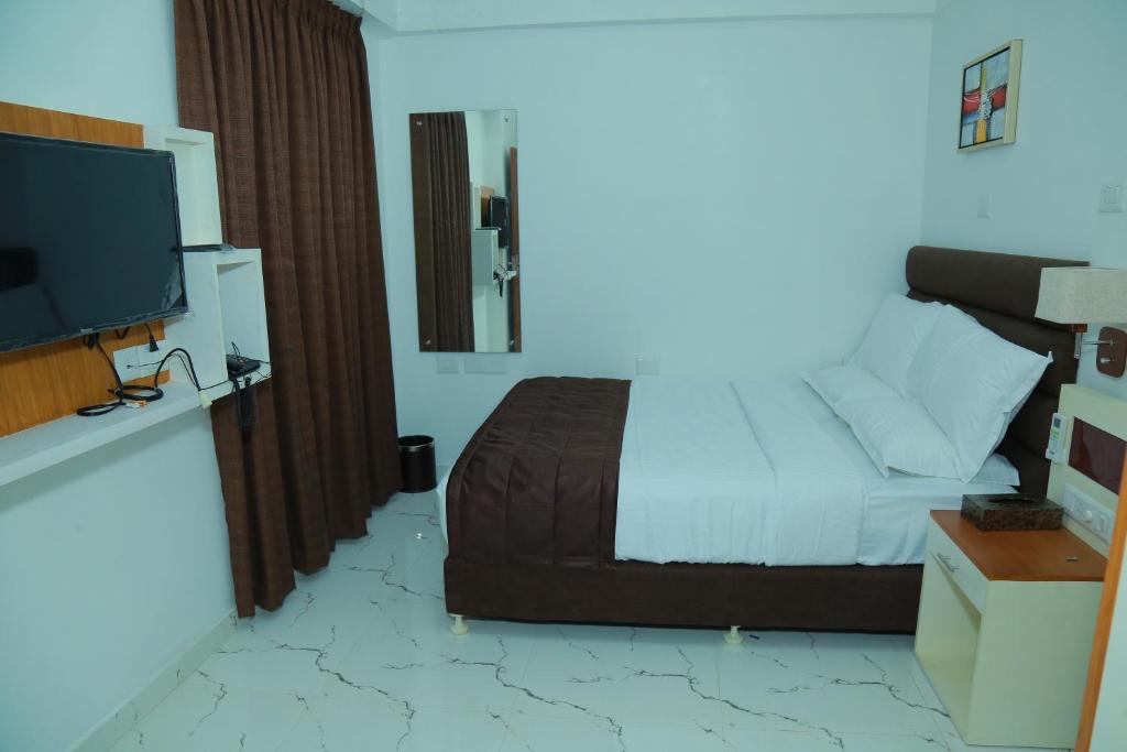 Postel nebo postele na pokoji v ubytování Utsavam Hotel Apartments