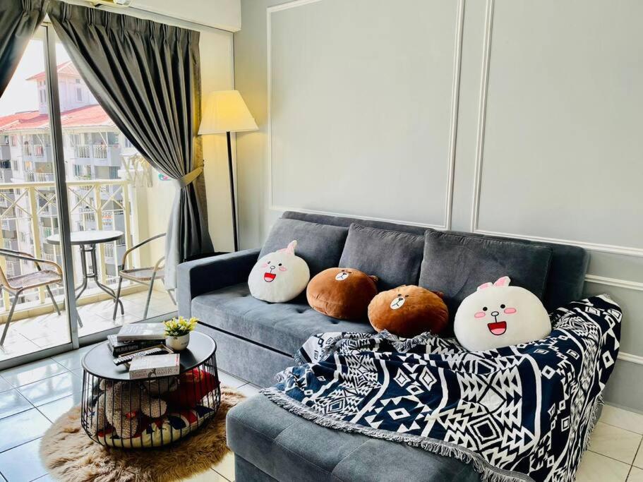 four pillows on a blue couch in a living room at 9 pax Homestay near Axiata Arena & Pavilion 2 in Kuala Lumpur