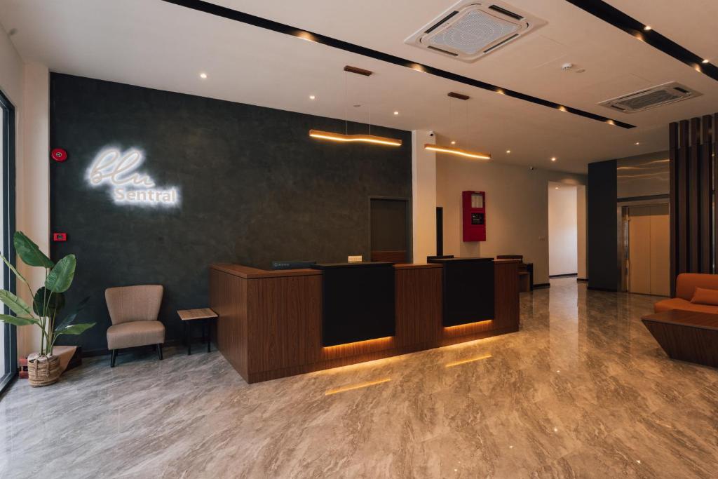 an office lobby with a reception desk and chairs at Blu Sentral Hotel in Tawau