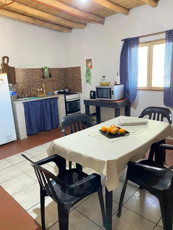 a kitchen with a table and chairs and a kitchen with a table at BYLELA in Tinogasta