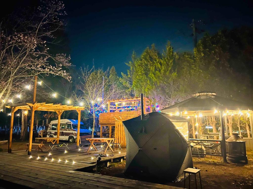 Eniwa的住宿－キャンパーズエリア恵庭 TCS Village，公园里晚上有帐篷和灯