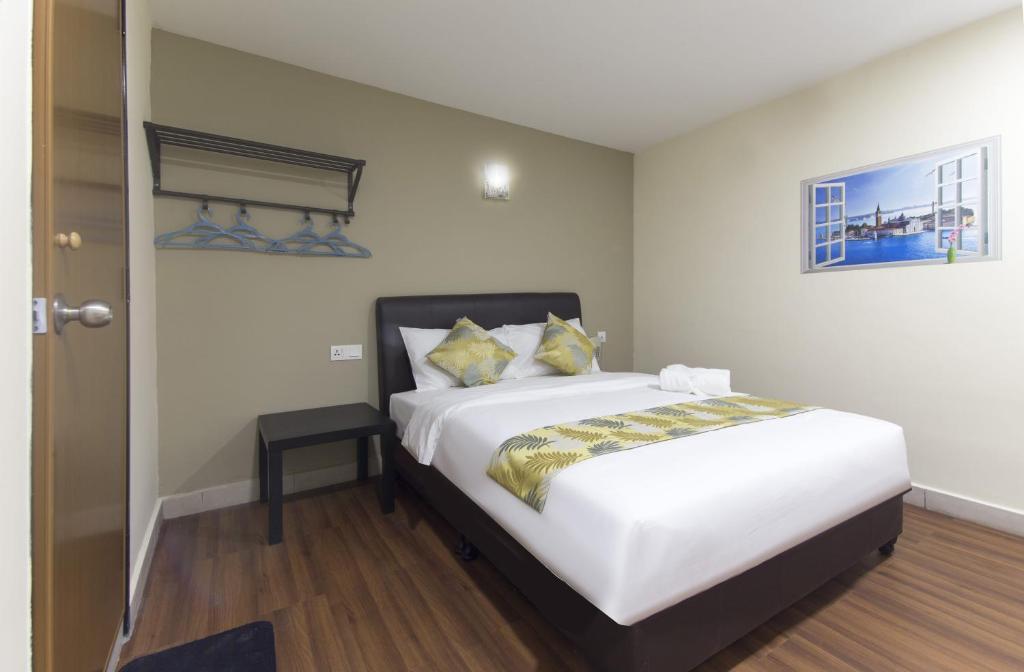 Hotel Sunjoy9 @ Mid Valley في كوالالمبور: غرفة نوم بسرير ابيض كبير مع مخدات صفراء