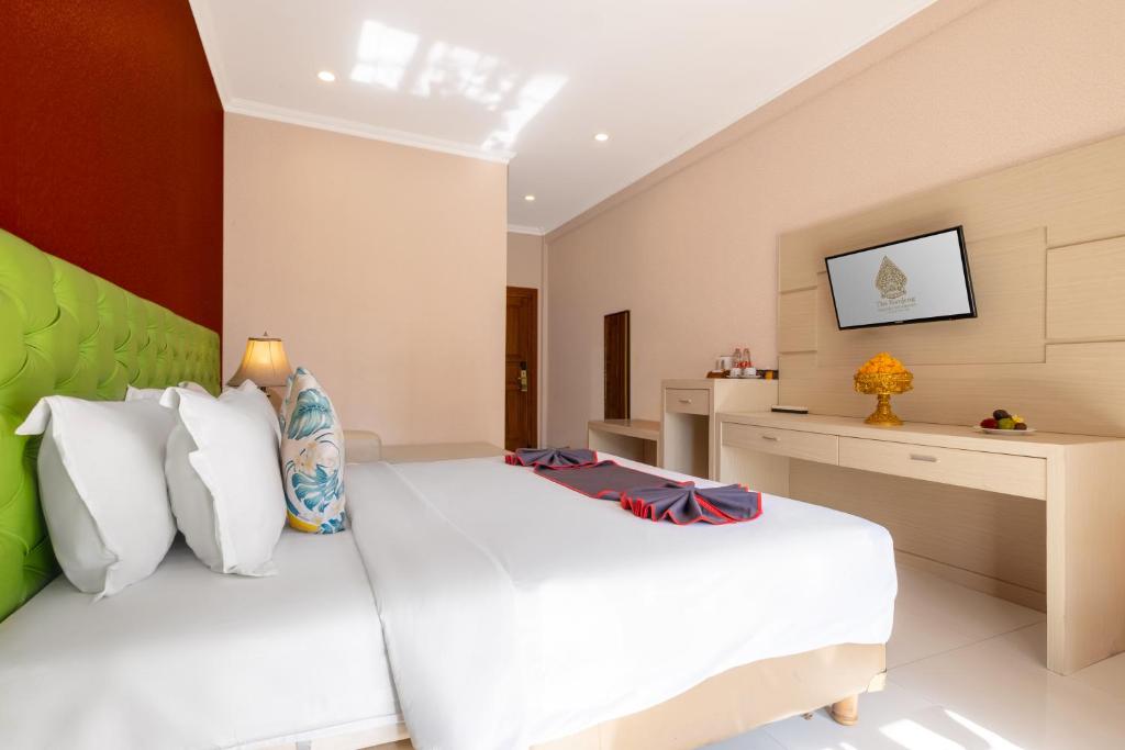 1 dormitorio con 1 cama blanca grande en una habitación en The Kanjeng Hotel Kuta en Kuta