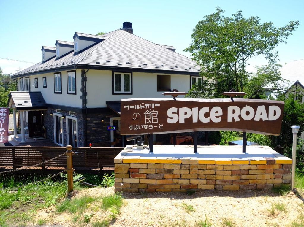 a street sign in front of a house at ワールドカリーの館　すぱいすろーど in Matsukawa