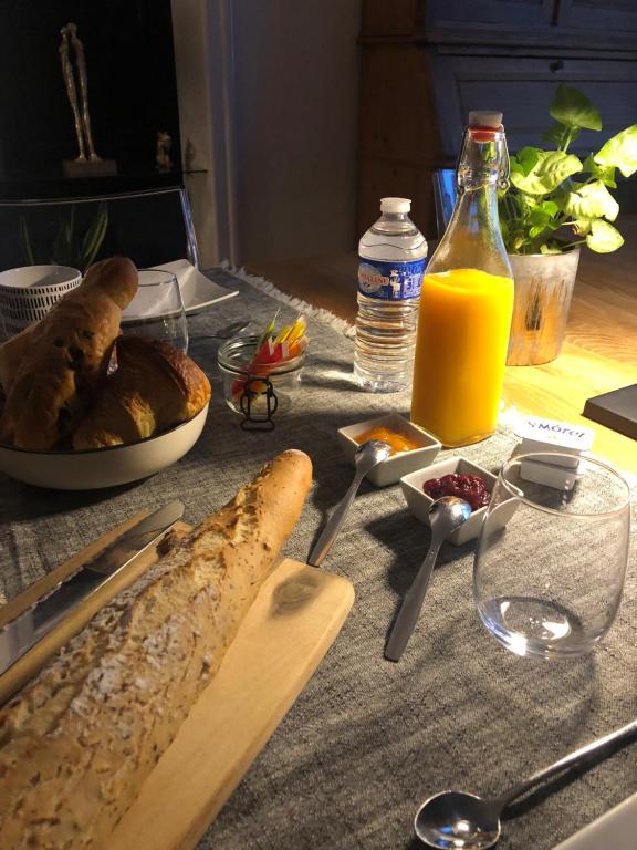 een tafel met een brood en een fles jus d'orange bij Le 8 in Mutzig