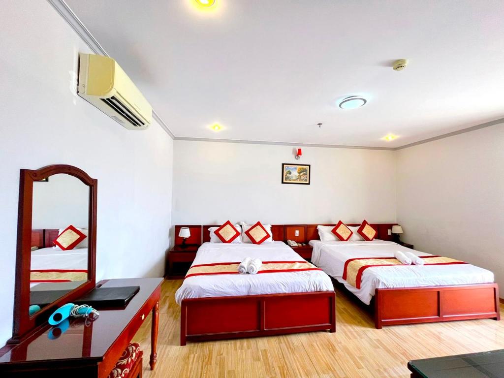 1 Schlafzimmer mit 2 Betten und einem Spiegel in der Unterkunft Asia Hotel Can Tho in Cần Thơ