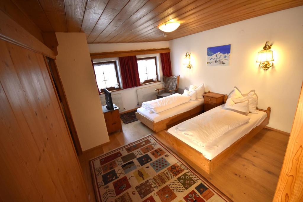 - une chambre avec un lit et un canapé dans l'établissement Brunnenhof Apartments, à Pettneu am Arlberg