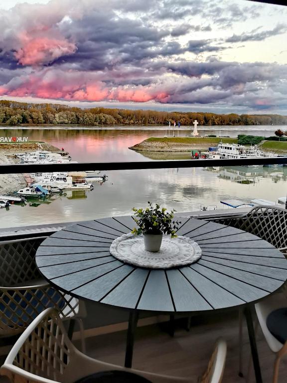 a table on a balcony with a view of a marina at Goreta032 Luxury Apartment 2 in Vukovar