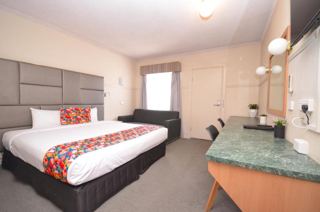 a hotel room with a bed and a desk at Ben Chifley Motor Inn in Bathurst