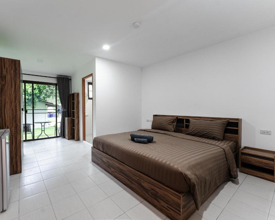 a bedroom with a large bed in a room at Apollo Hotel Chalong in Ban Suan