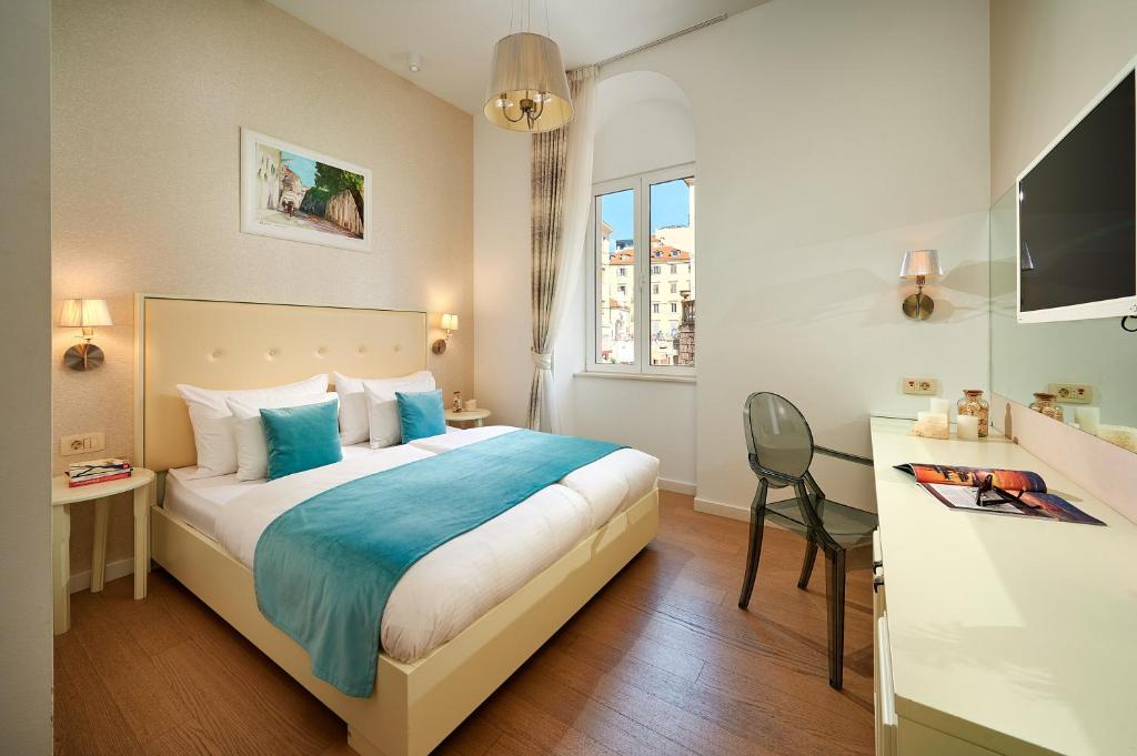 a hotel room with a bed and a desk at Olea Luxury Rooms in Split
