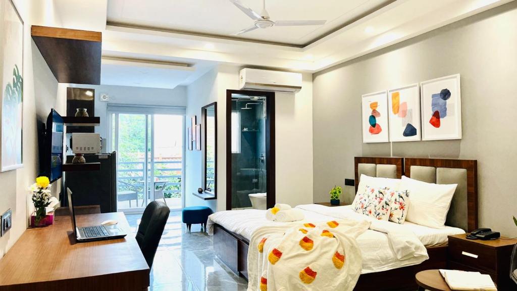 a bedroom with a bed and a desk with a laptop at BluO Studio2 DLF Cybercity - Balcony, Gym TT, Lift in Gurgaon