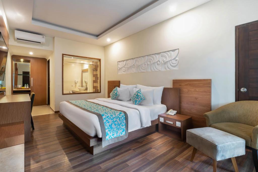 a hotel room with a bed and a chair at Adhi Jaya Hotel in Kuta