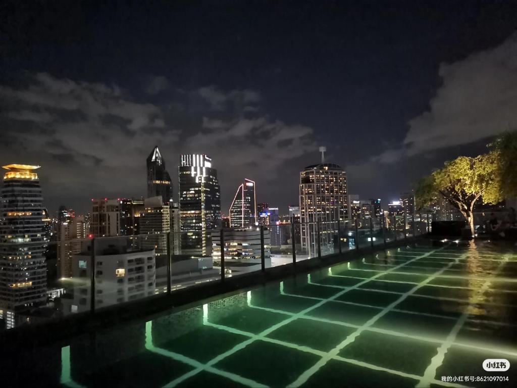 a view of a city skyline at night at 小憩 屋顶无边泳池 terminal21 Phrom phong Asok 21航站楼 阿索 in Bangkok