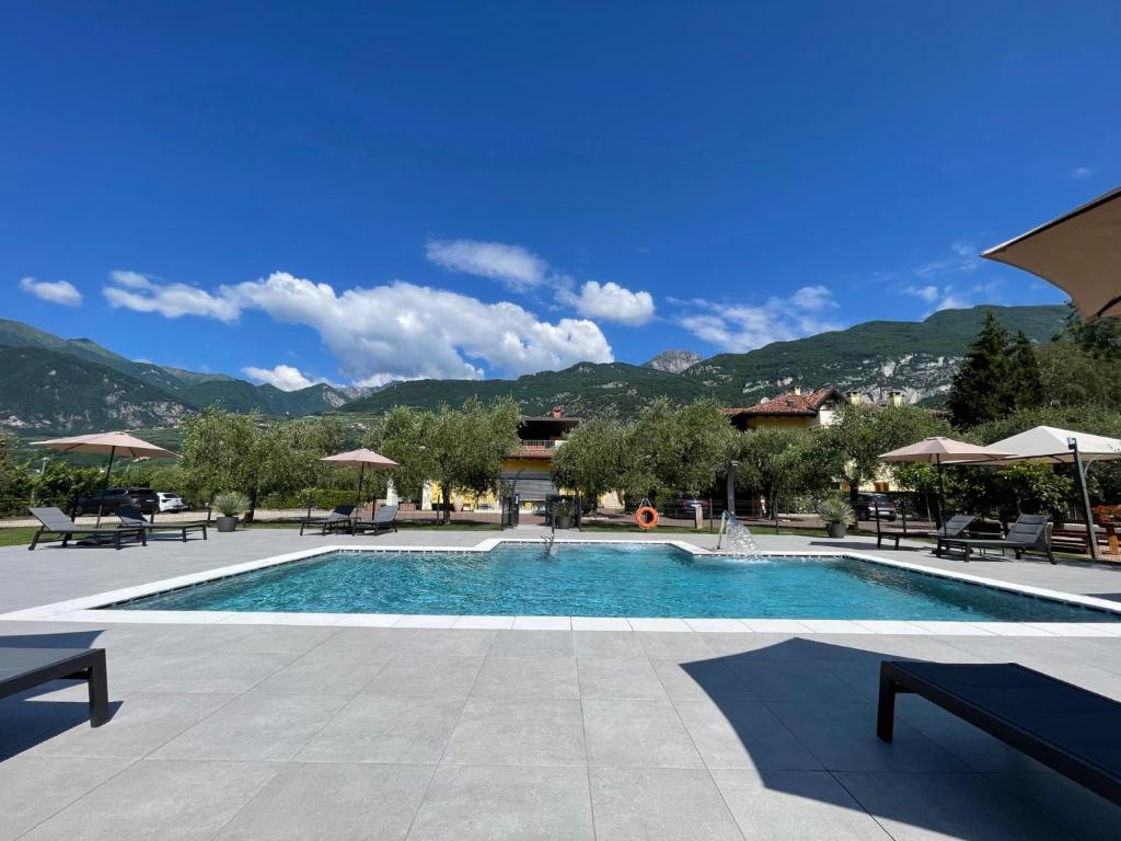 a swimming pool with tables and chairs and mountains at Arcovacanze in Arco