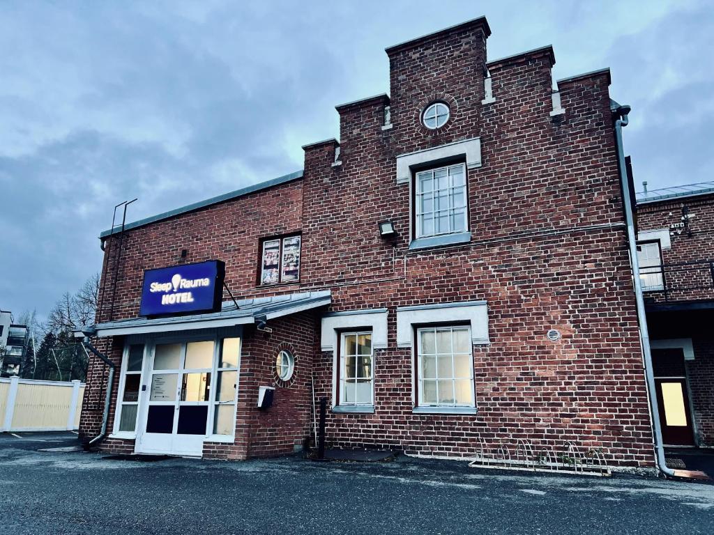 een bakstenen gebouw met een klok aan de zijkant bij Hotel Sleep at Rauma in Rauma