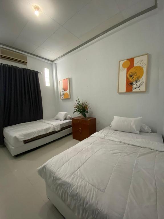 a bedroom with two beds in a room at Lorent Hostel Near Padang Beach in Padang